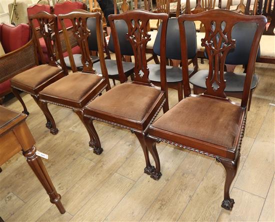 A set of four Chippendale style chairs with plain upholstered seats on cabriole legs with claw and ball feet